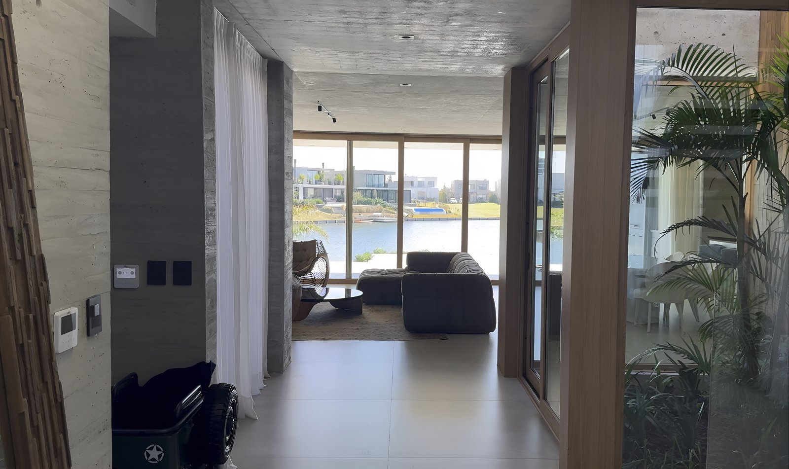 Sala de estar moderna com vista para a água e muita luz — projeto CASA MHN, por Hermann Arquitectos, em Nordelta
